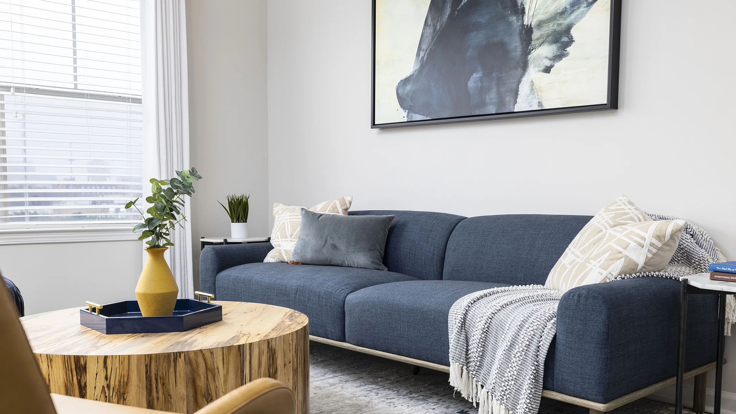 Chic living room with a cozy blue sofa, stylish wooden coffee table, and modern decor accents.