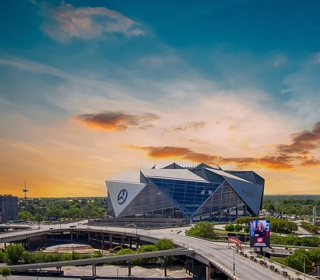 Breathtaking urban landscape with a stunning architectural stadium under a vibrant sunset sky, showcasing modern metropolitan life.