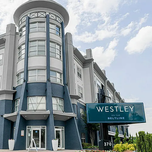 Contemporary apartment building with modern design, large windows, and lush greenery at 'Westley on the Beltline'.
