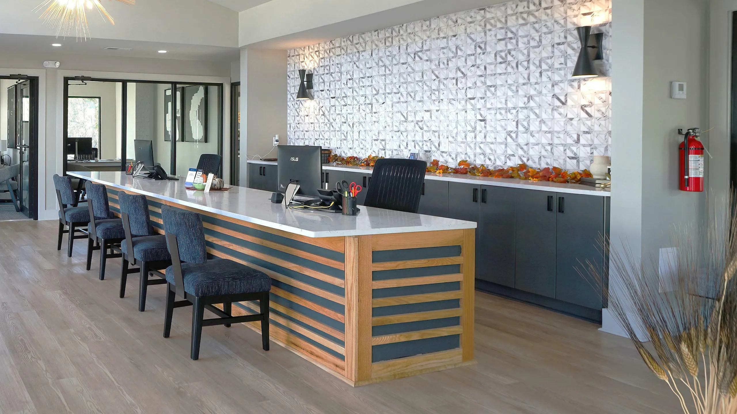 Modern and inviting office space featuring sleek design, textured wall accents, and ambient lighting with comfortable seating.