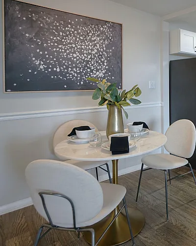 Inviting kitchen with stainless steel appliances, sleek white cabinets, and chic dining area with modern decor.