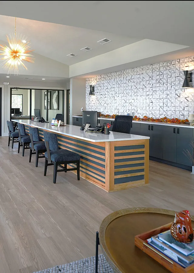 Contemporary office space with chic decor, featuring a sleek wooden desk, stylish chairs, and elegant lighting, ideal for modern business settings.