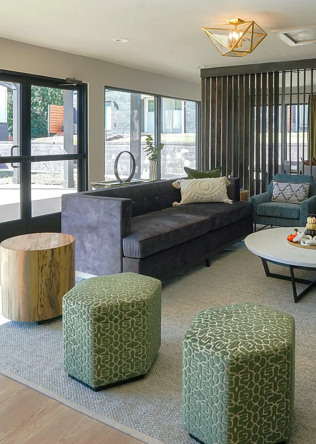 Modern and inviting living room with large windows, stylish furniture, and natural light streaming in.