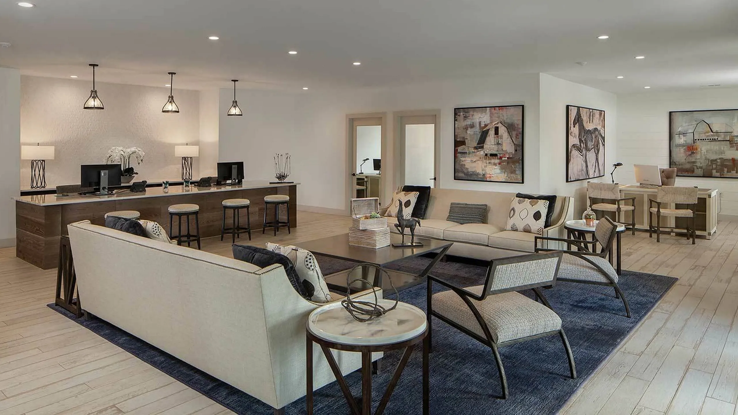 Luxurious open-concept living area with modern decor, featuring a stylish seating arrangement, elegant lighting, and tasteful artwork for a sophisticated ambiance.