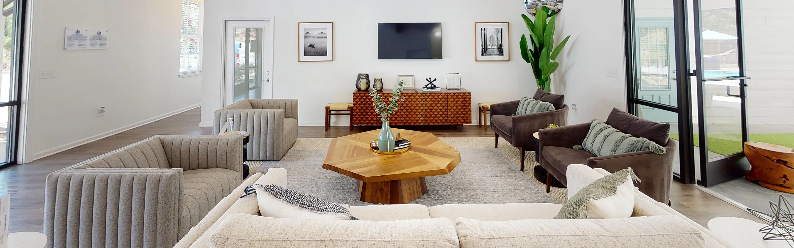 Inviting living room with plush seating, elegant chandelier, modern decor, and abundant natural light.