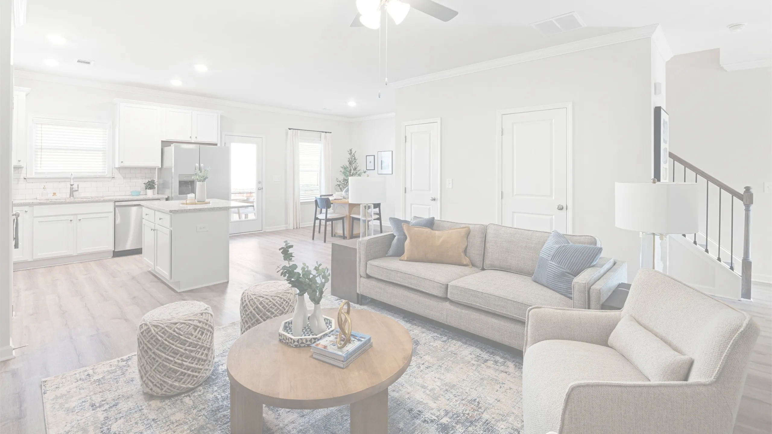 Bright and modern open-concept living space featuring a cozy seating area, stylish dining nook, and sleek kitchen with stainless steel appliances.