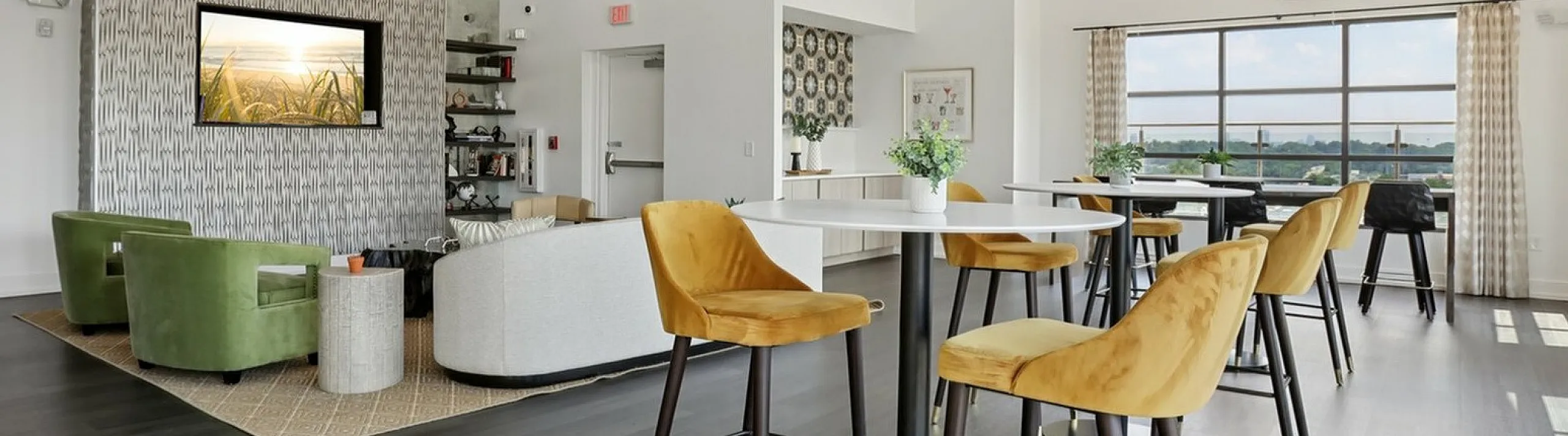Chic open living space with elegant pendant lighting, plush seating, stylish wall decor, and large windows offering panoramic views.