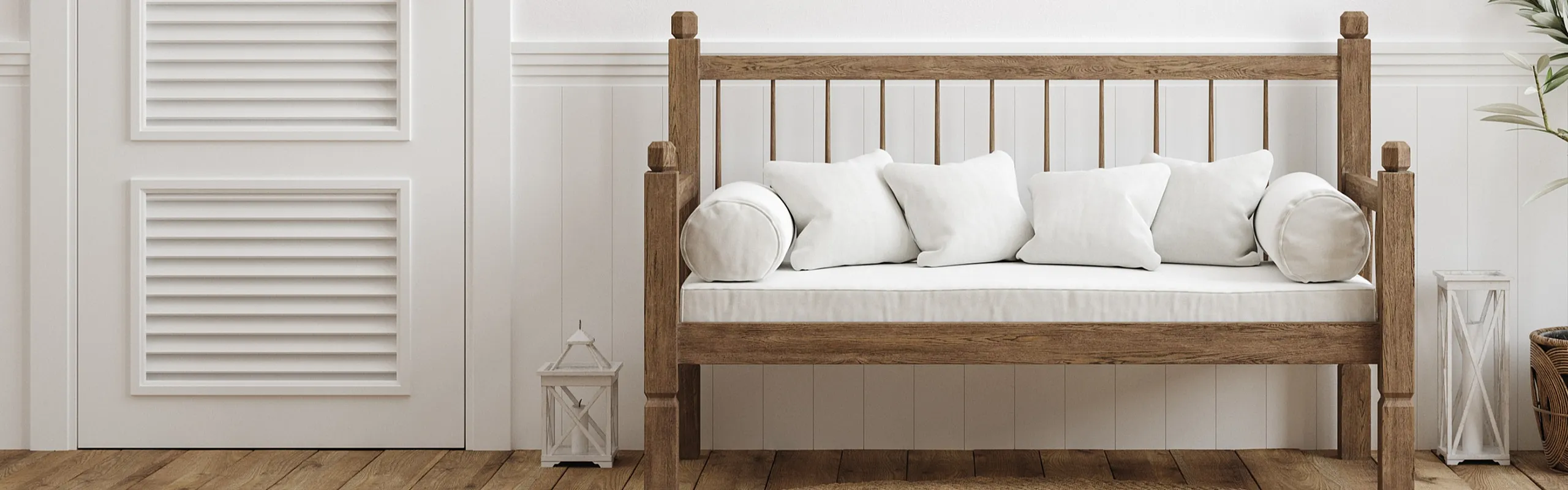 Elegant minimalist living space with a cozy wooden bench, plush white cushions, and a stylish potted plant on a warm hardwood floor.