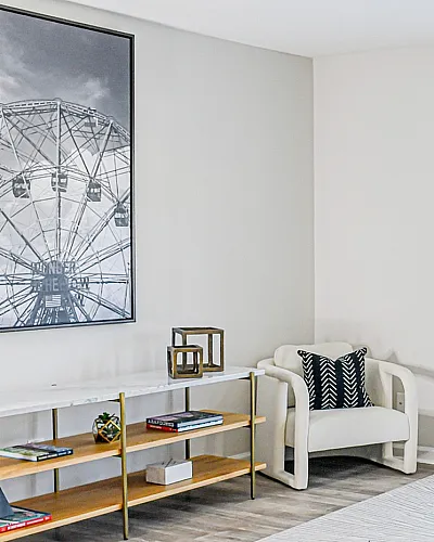 Bright and modern living room with cozy gray sofa, stylish decor, and large artwork showcasing a ferris wheel.