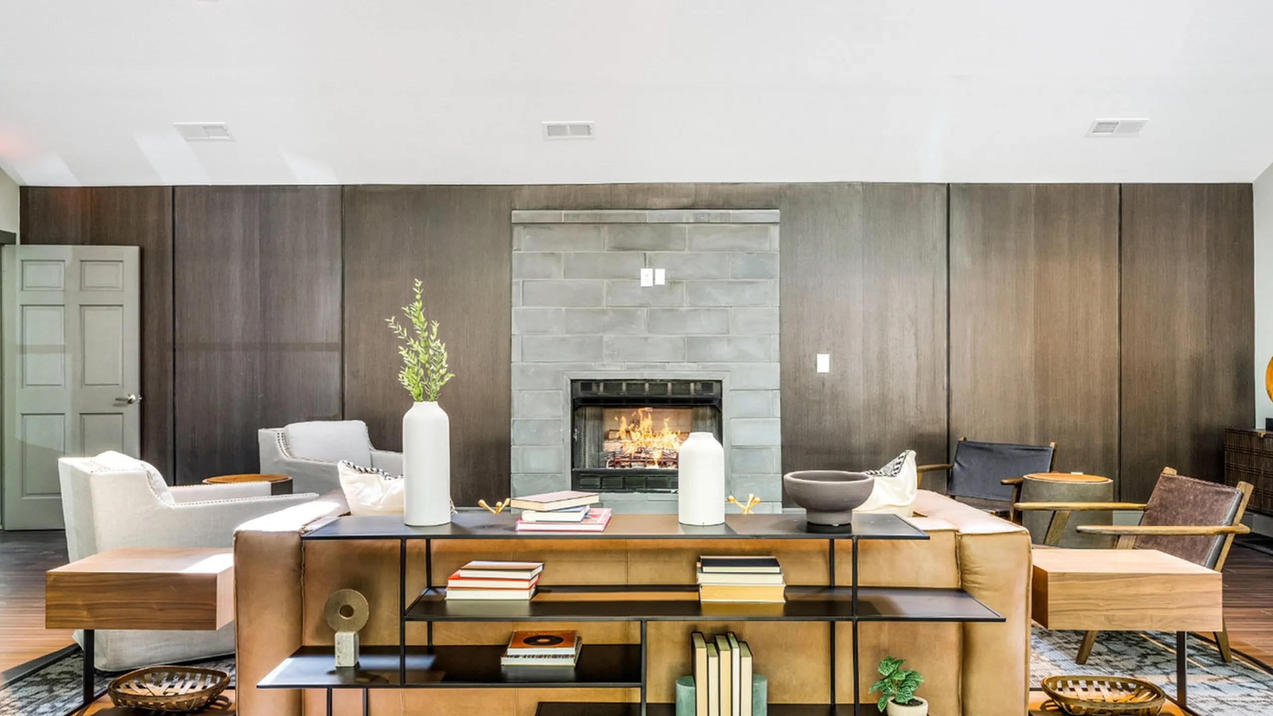 Elegant living room with modern fireplace, plush sofas, and sleek open shelves, creating a warm and inviting ambiance.