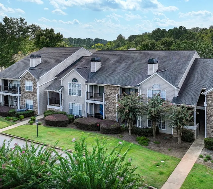 Charming apartment complex surrounded by lush greenery, featuring modern architecture and inviting balconies.
