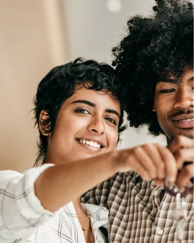 happy couple showing keys to new apartment