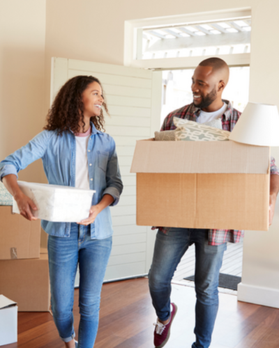Happy couple moving into a bright, spacious apartment filled with natural light and stylish hardwood floors.