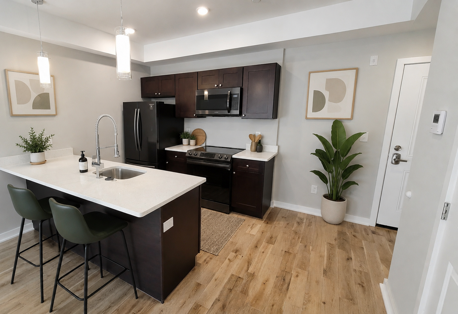 Modern kitchen featuring dark cabinetry, elegant countertops, and stylish overhead lighting. Includes a spacious island with seating, sleek appliances, and decorative plants for a fresh touch.