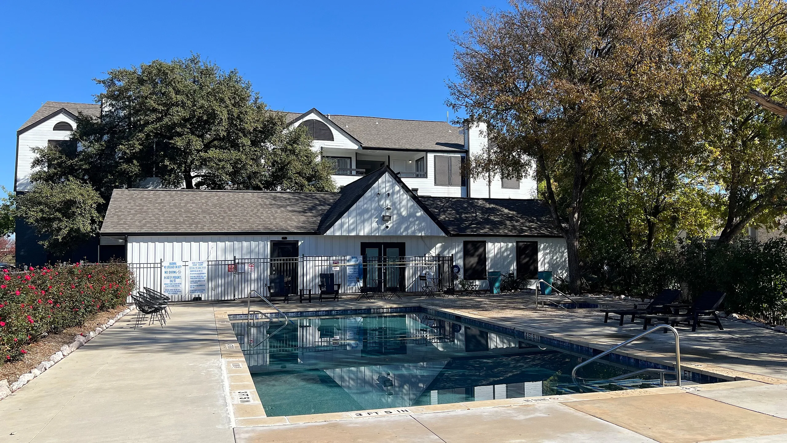 Inviting apartment complex featuring a sparkling pool, lush landscaping, and contemporary architecture, perfect for relaxation and community living.