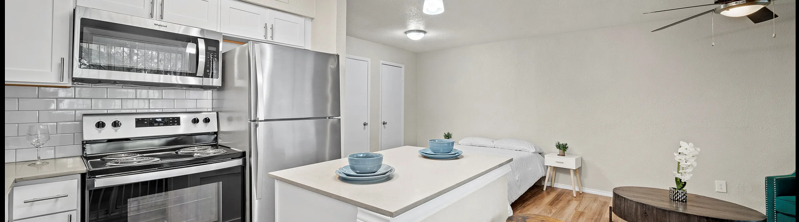 Modern studio apartment with contemporary kitchen featuring stainless steel appliances and a cozy living area with stylish decor.