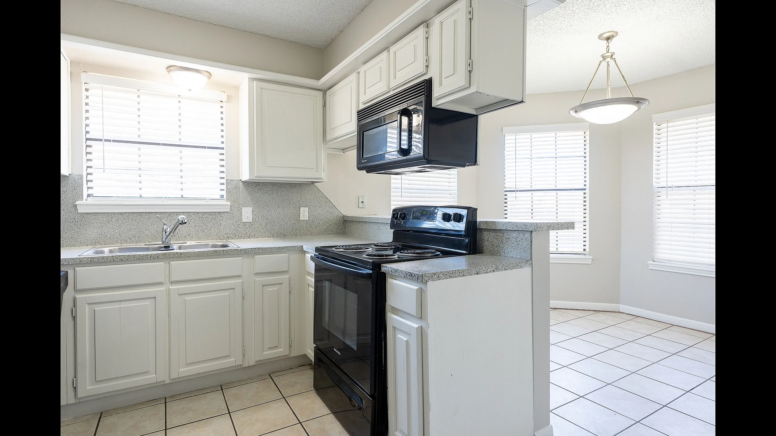 Bright and airy kitchen with modern appliances, gleaming white cabinets, and abundant natural light.