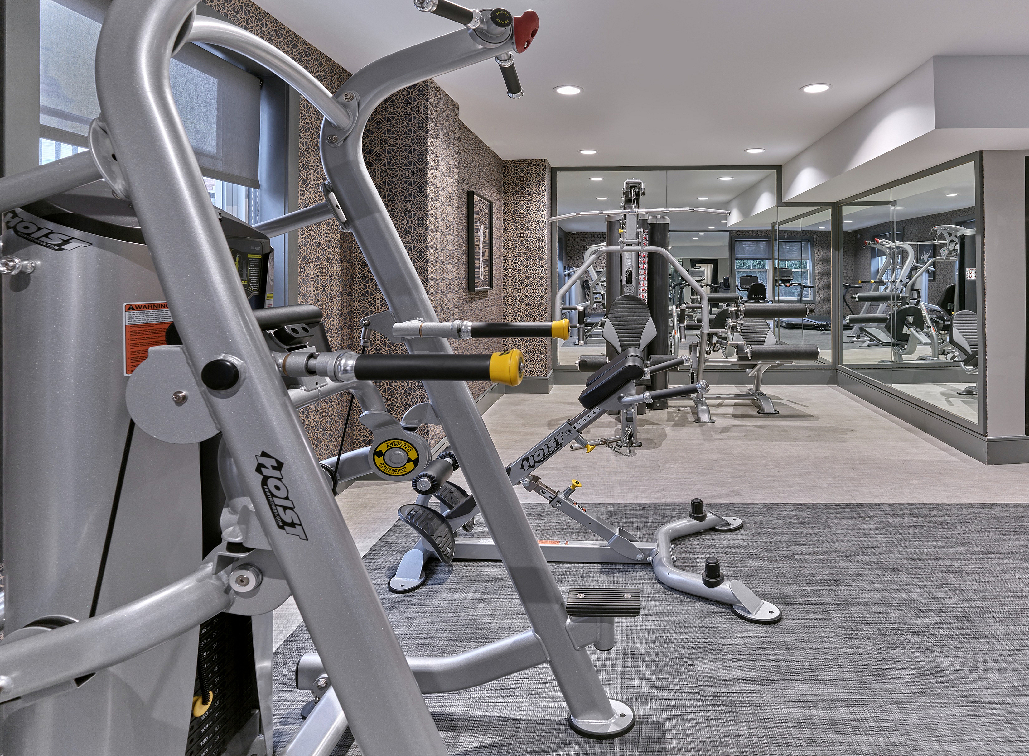 Elegant fitness center with advanced exercise equipment and mirrored walls, offering a tasteful workout space.