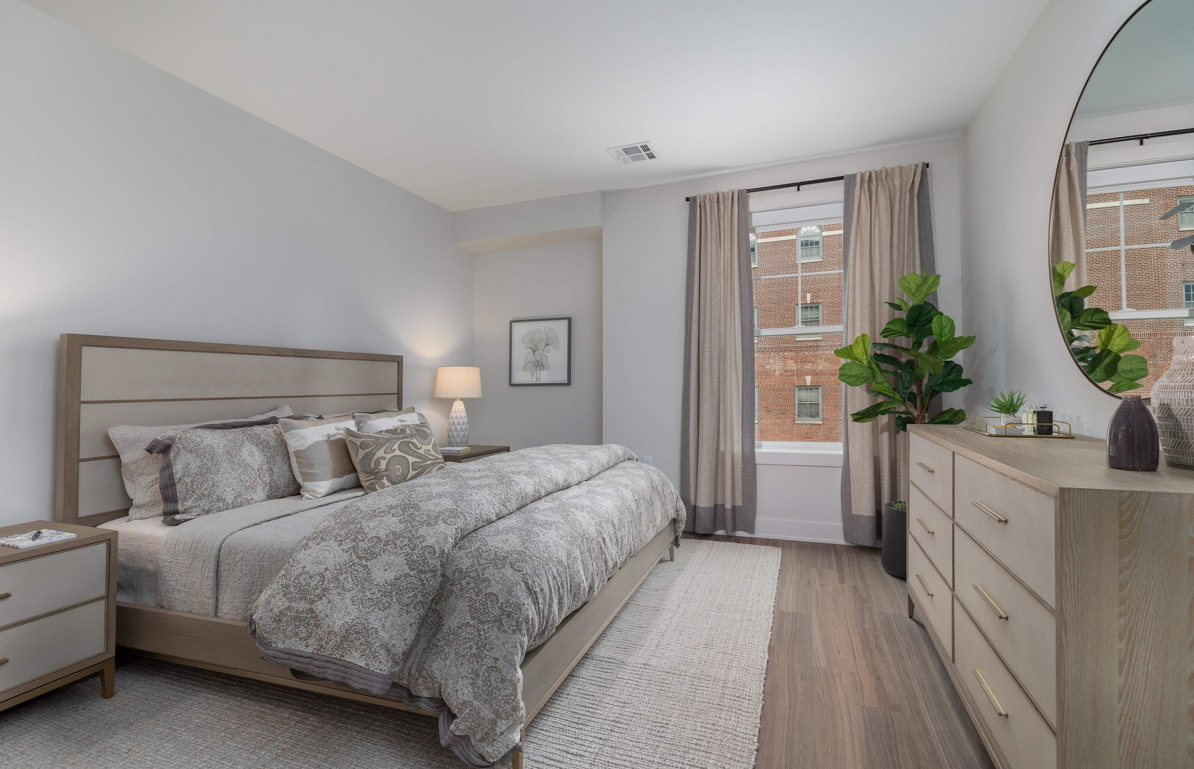 Chic bedroom featuring a plush bed, modern decor, and large windows with outdoor views.