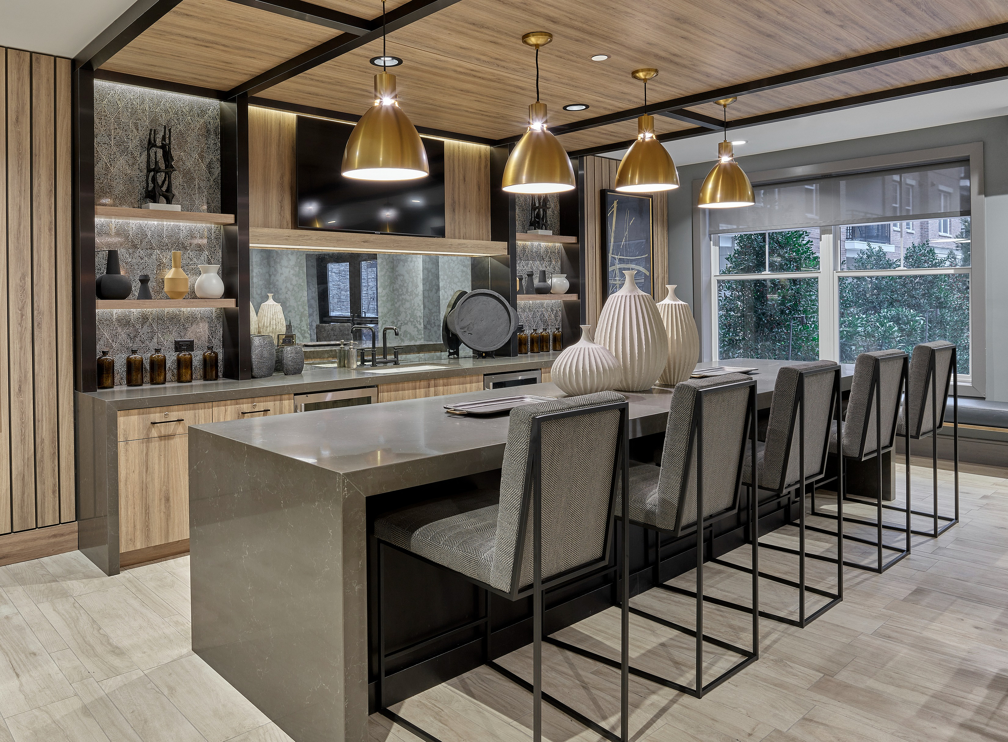Stylish modern kitchen featuring a large island, bar stools, pendant lighting, and contemporary decor.
