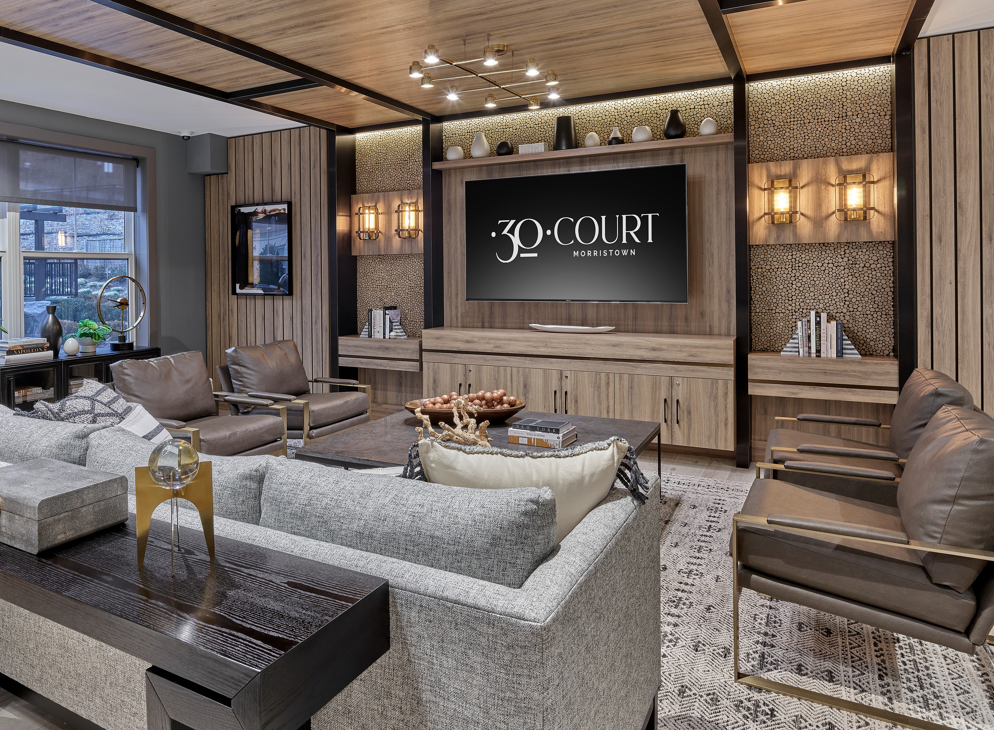 Sophisticated living room with modern decor, featuring a stylish wooden wall unit, plush seating, and elegant lighting.