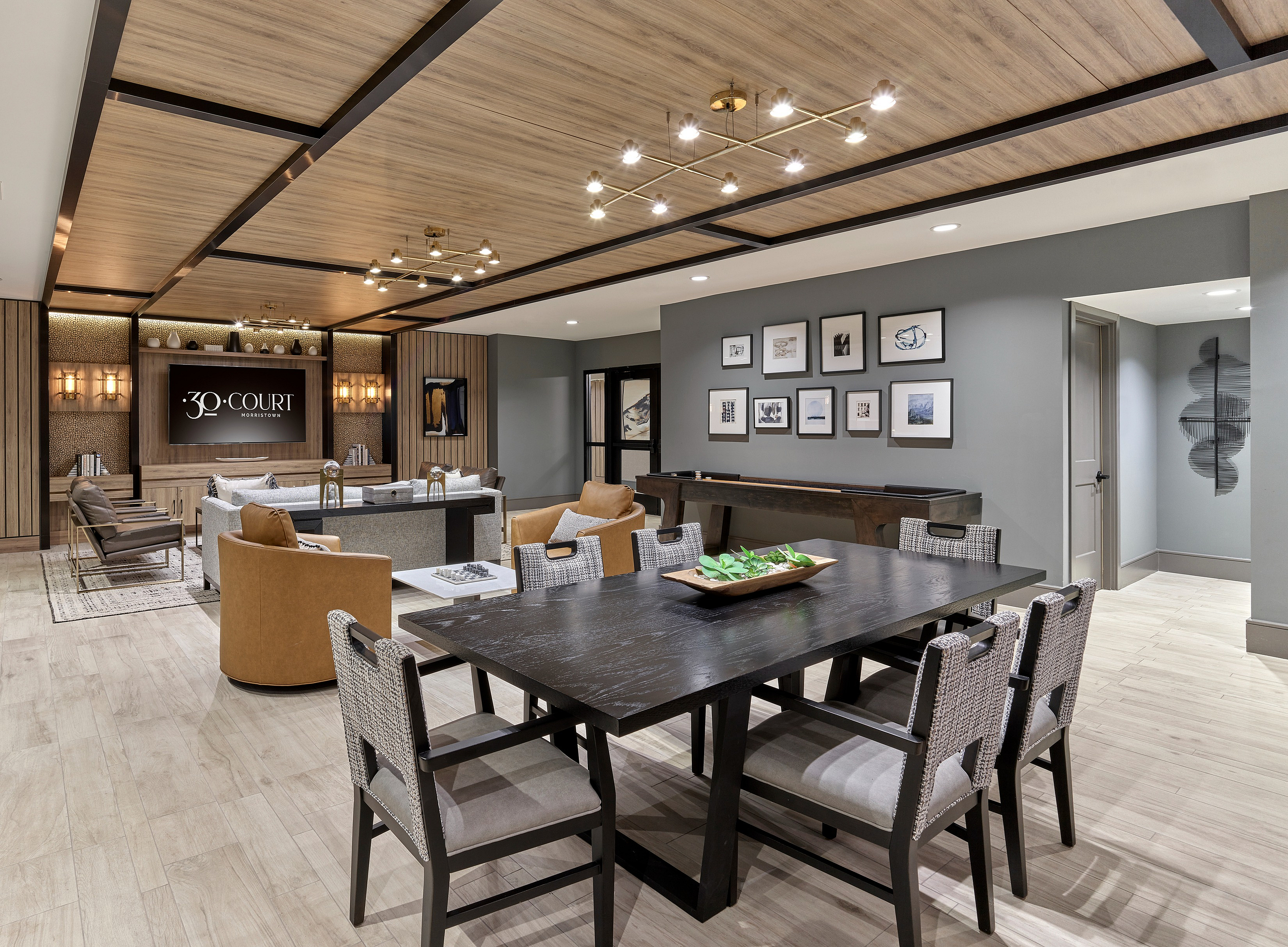 Sophisticated lounge space featuring modern seating, a large dining table, and stylish wall art.