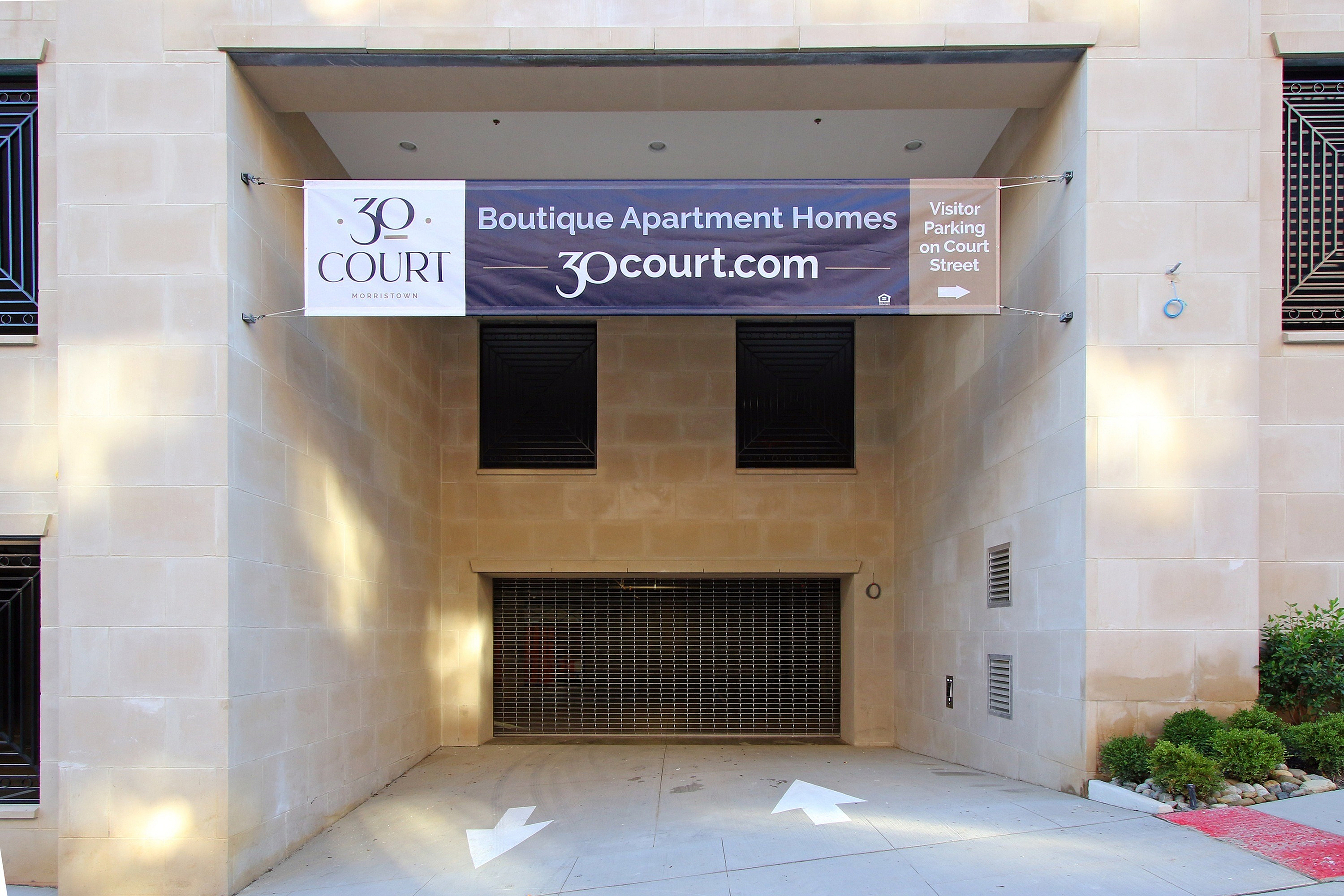 Entrance to 30 Court Boutique Apartment Homes with a welcoming sign and visitor parking directions.