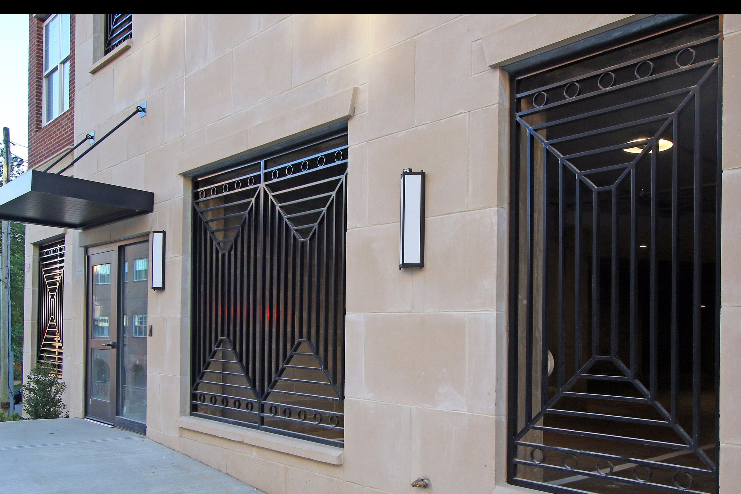Elegant private parking entrance with decorative iron bars and a sleek awning.