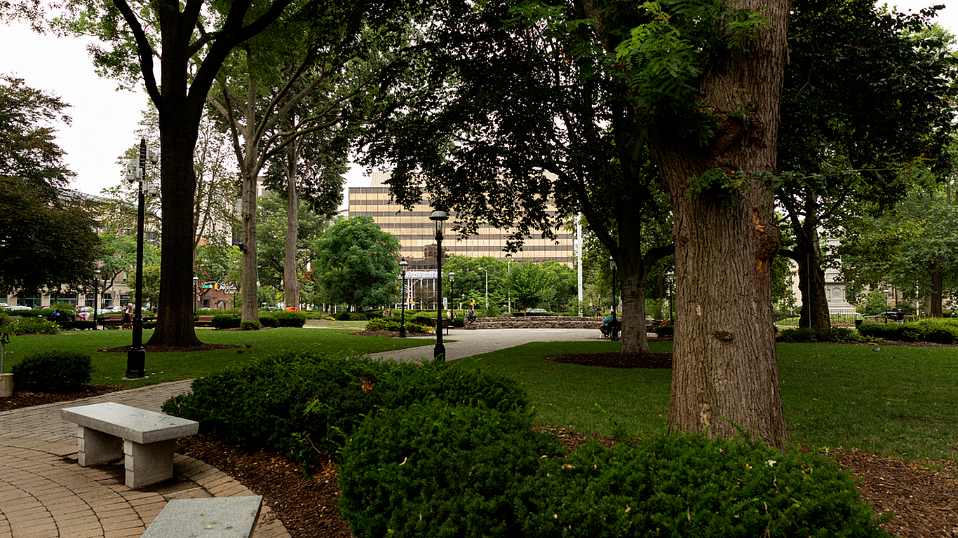 Charming city park view with lush greenery, towering trees, and well-maintained pathways, offering a tranquil escape in the heart of urban living.