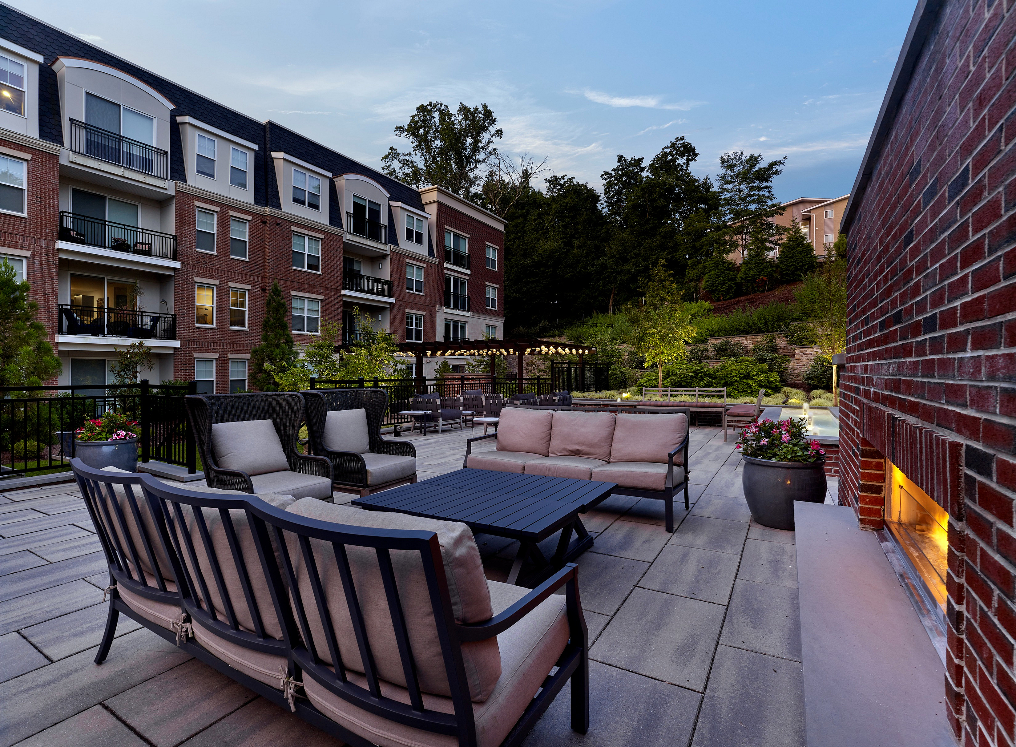 Chic outdoor lounge area with elegant seating and scenic views, surrounded by lush greenery and modern architecture.