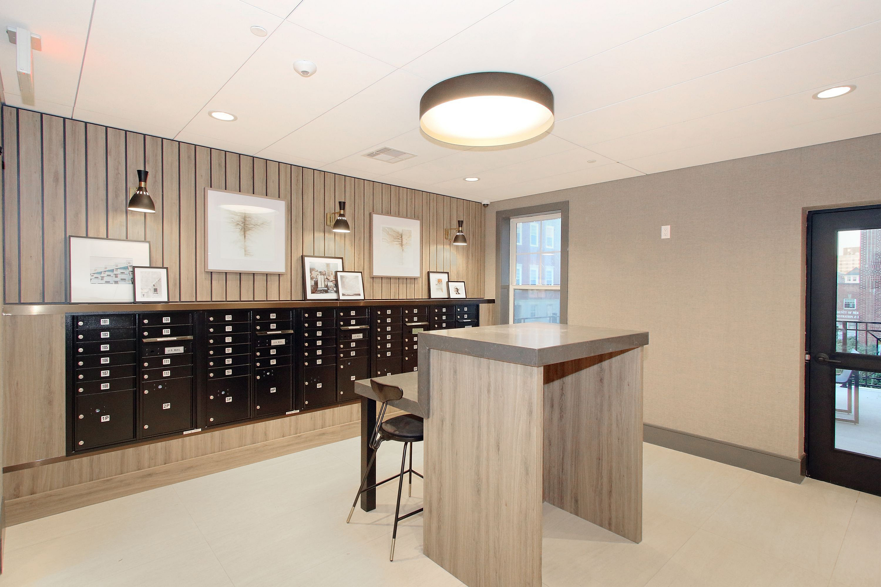 Modern lobby area with stylish wood paneling, secure mailboxes, and chic artwork, offering a welcoming and elegant entrance.