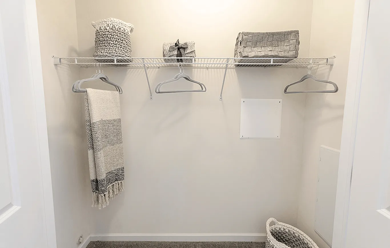 Inviting closet space with elegant storage baskets and cozy towels, offering functionality and style.