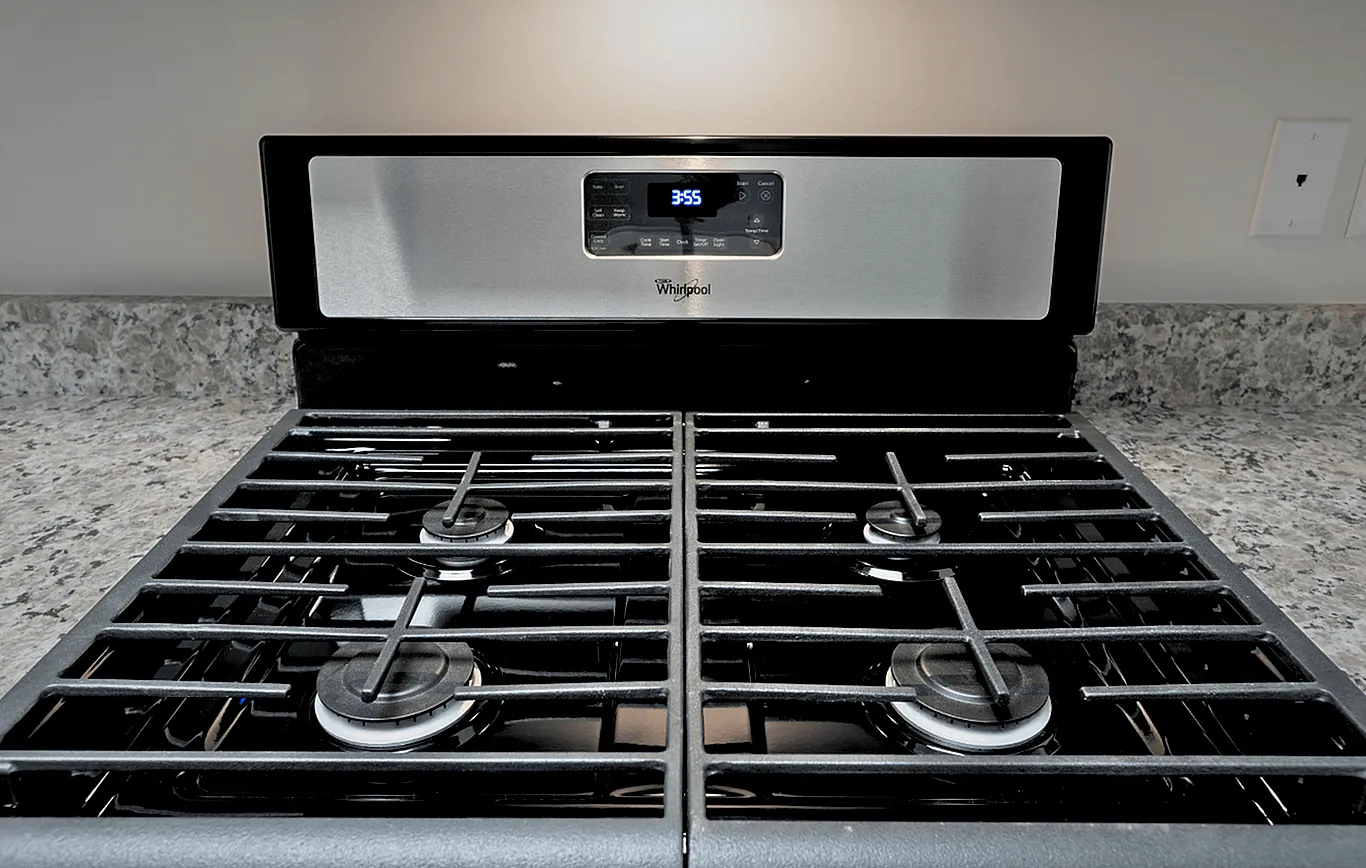 Sleek modern kitchen stovetop featuring a stainless steel range and four burners, perfect for culinary enthusiasts.