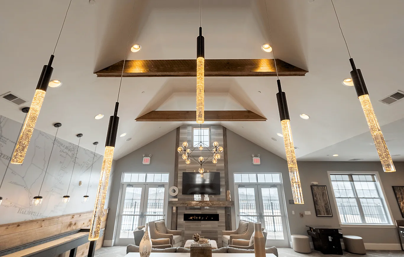 Elegant apartment living room with modern chandelier, cozy seating, and large windows for natural light.