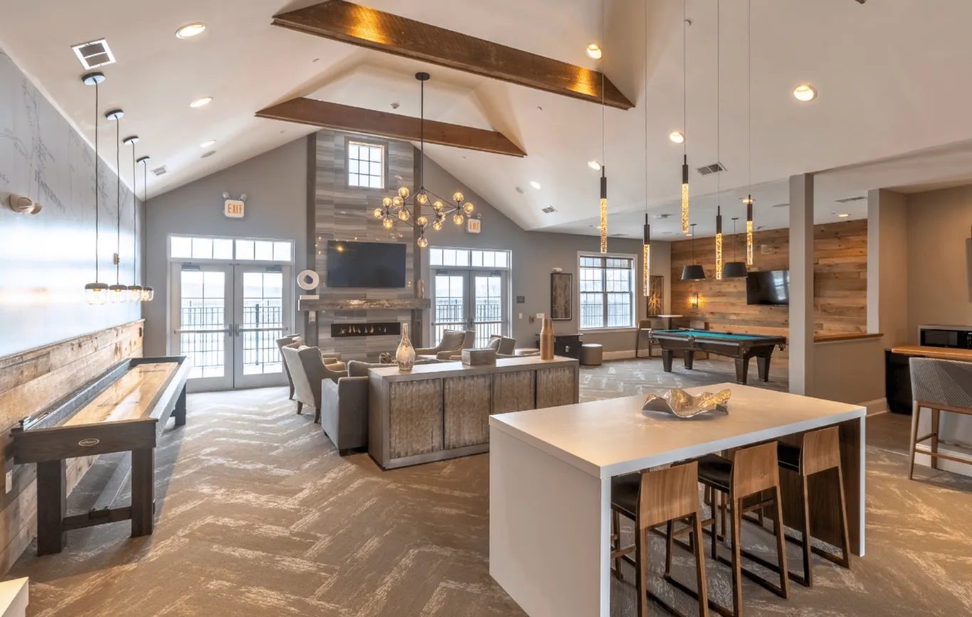 Elegant and spacious lounge area featuring modern lighting, a cozy fireplace, stylish seating, and a pool table creating the perfect entertainment space.