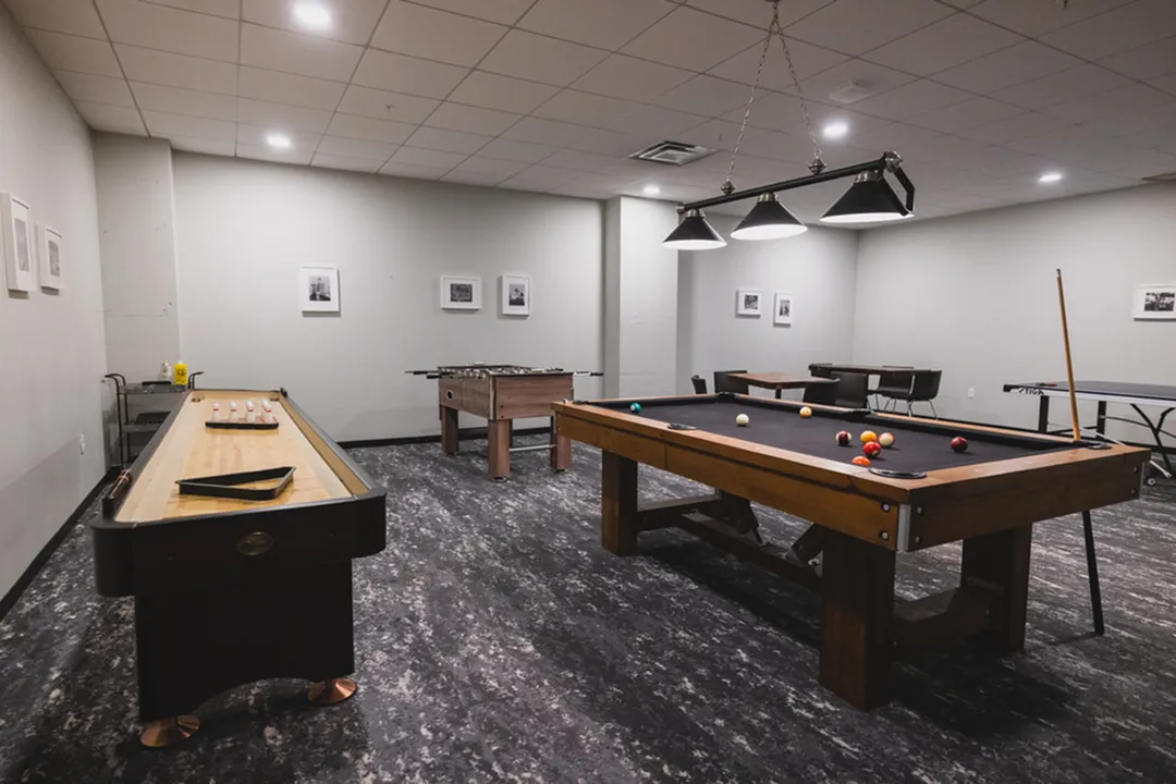 Vibrant game room with a billiards table, foosball, and shuffleboard, perfect for entertainment and relaxation.