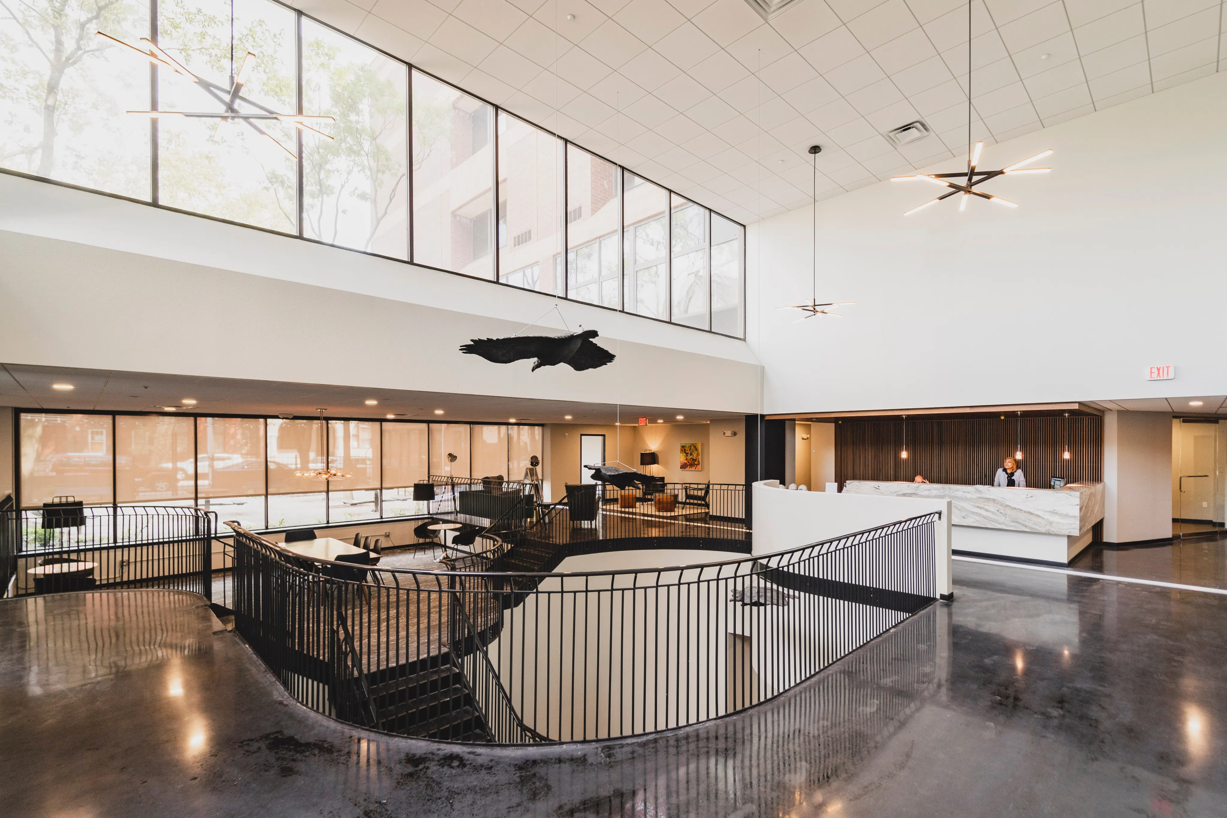 Inviting modern lobby with expansive windows, sleek fixtures, and elegant decor, creating a welcoming atmosphere.