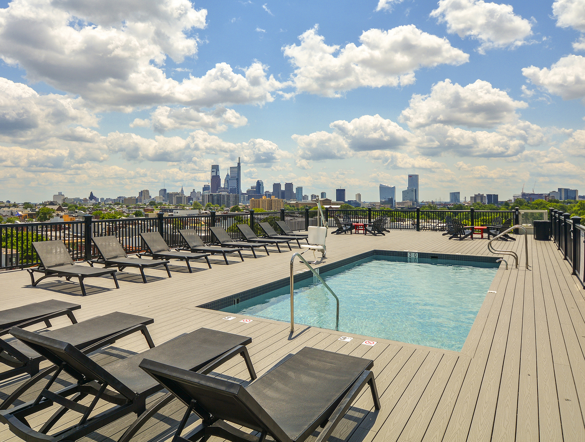 Luxurious rooftop pool area with stunning city skyline views, offering chic lounge chairs for ultimate relaxation.