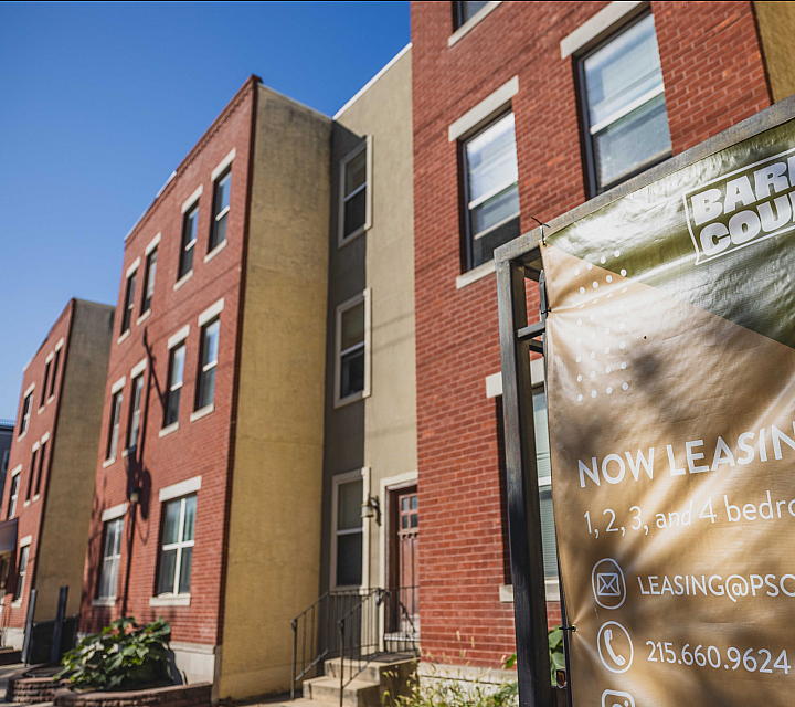Charming brick apartment building with a banner advertising leasing opportunities for 1, 2, 3, and 4-bedroom units.