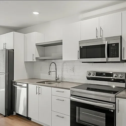 Sleek modern kitchen with stainless steel appliances, white cabinetry, and polished countertops.