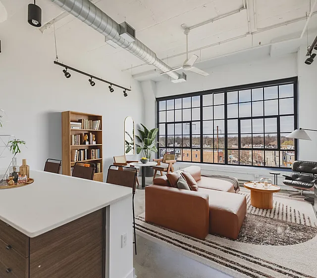 Chic urban loft with expansive windows, modern furnishings, and open-concept living area offering breathtaking city views.