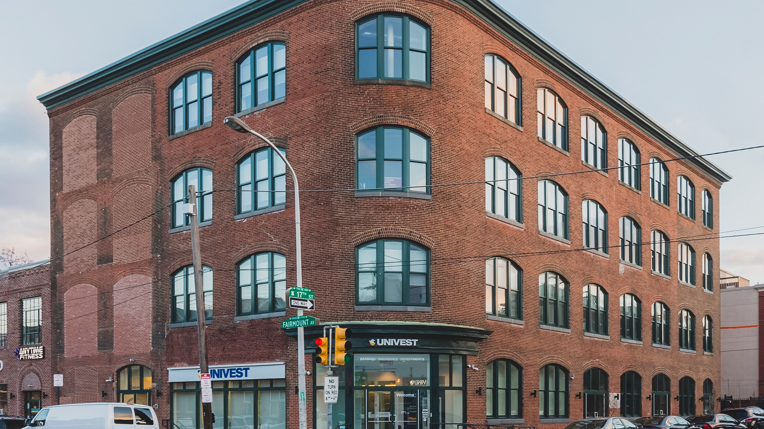 Charming historic-style brick building with large arched windows, perfect for urban living or professional space.