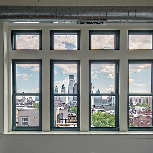 Chic urban apartment with expansive windows offering stunning skyline views and abundant natural light.
