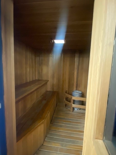Inviting sauna room with wooden benches and walls, creating a warm and relaxing atmosphere.