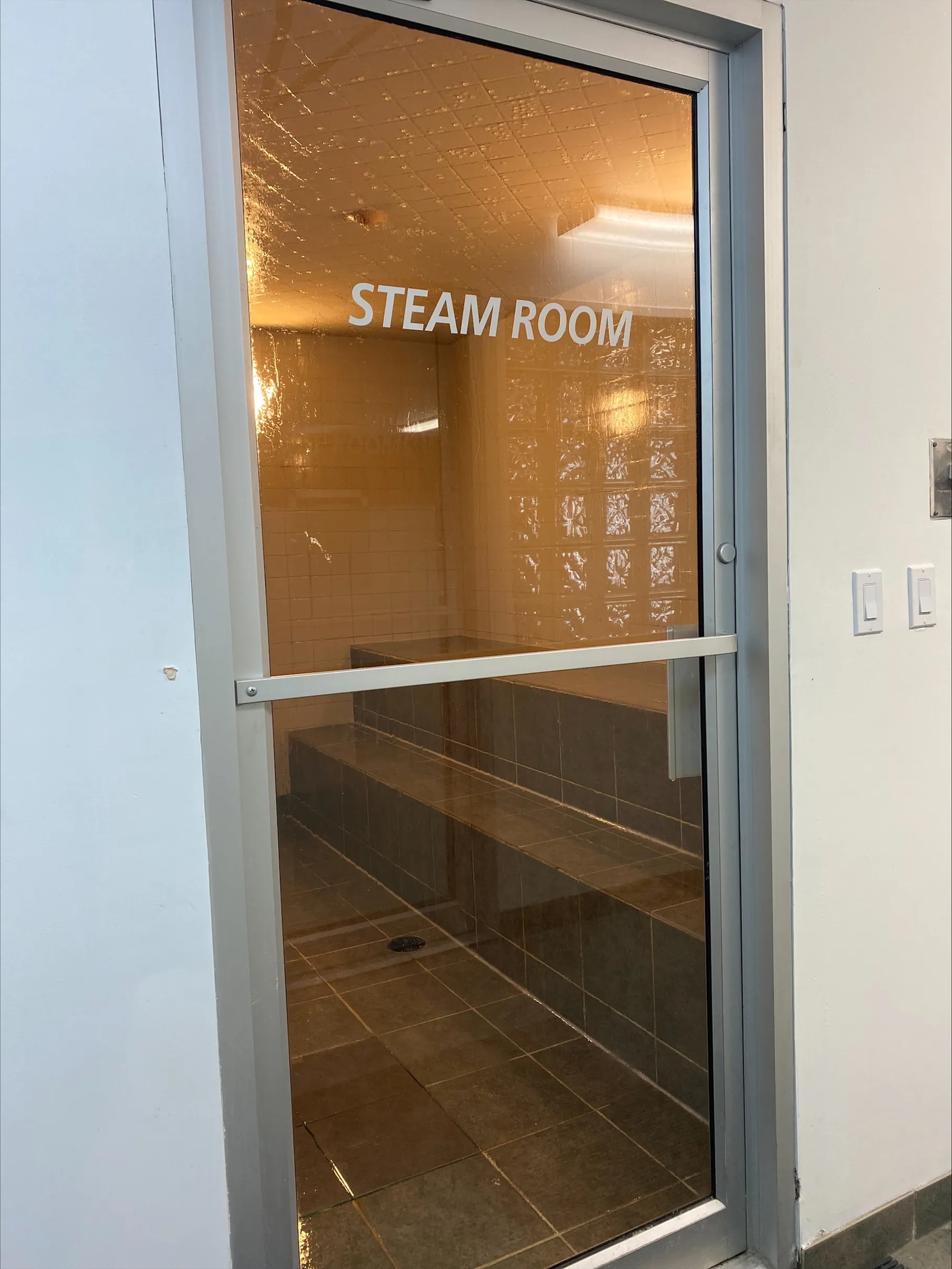 Inviting steam room with sleek glass door offering a rejuvenating retreat for relaxation.