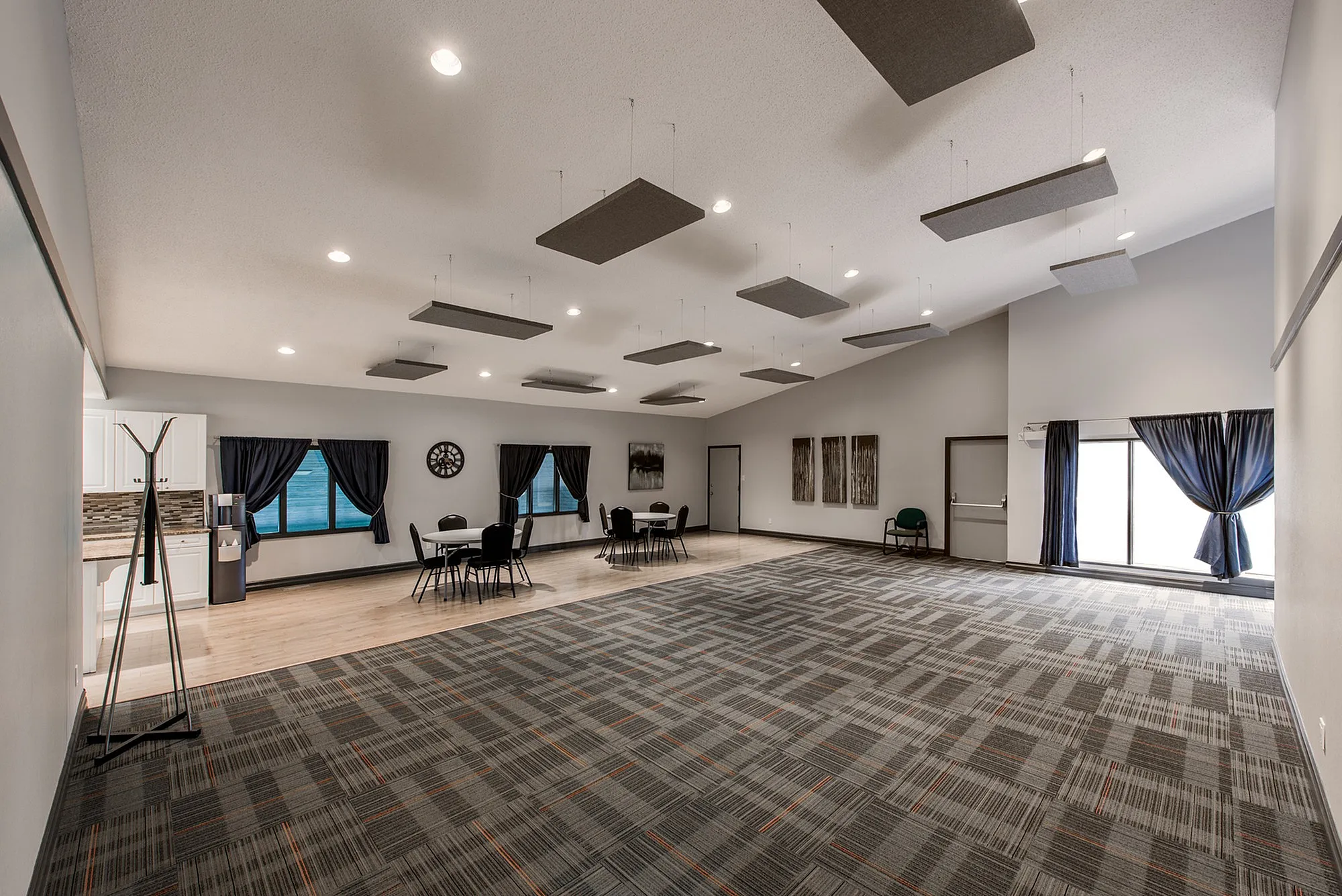 Spacious and modern open-concept room with stylish carpet flooring, contemporary wall decorations, and functional seating area, perfect for versatile events and gatherings.
