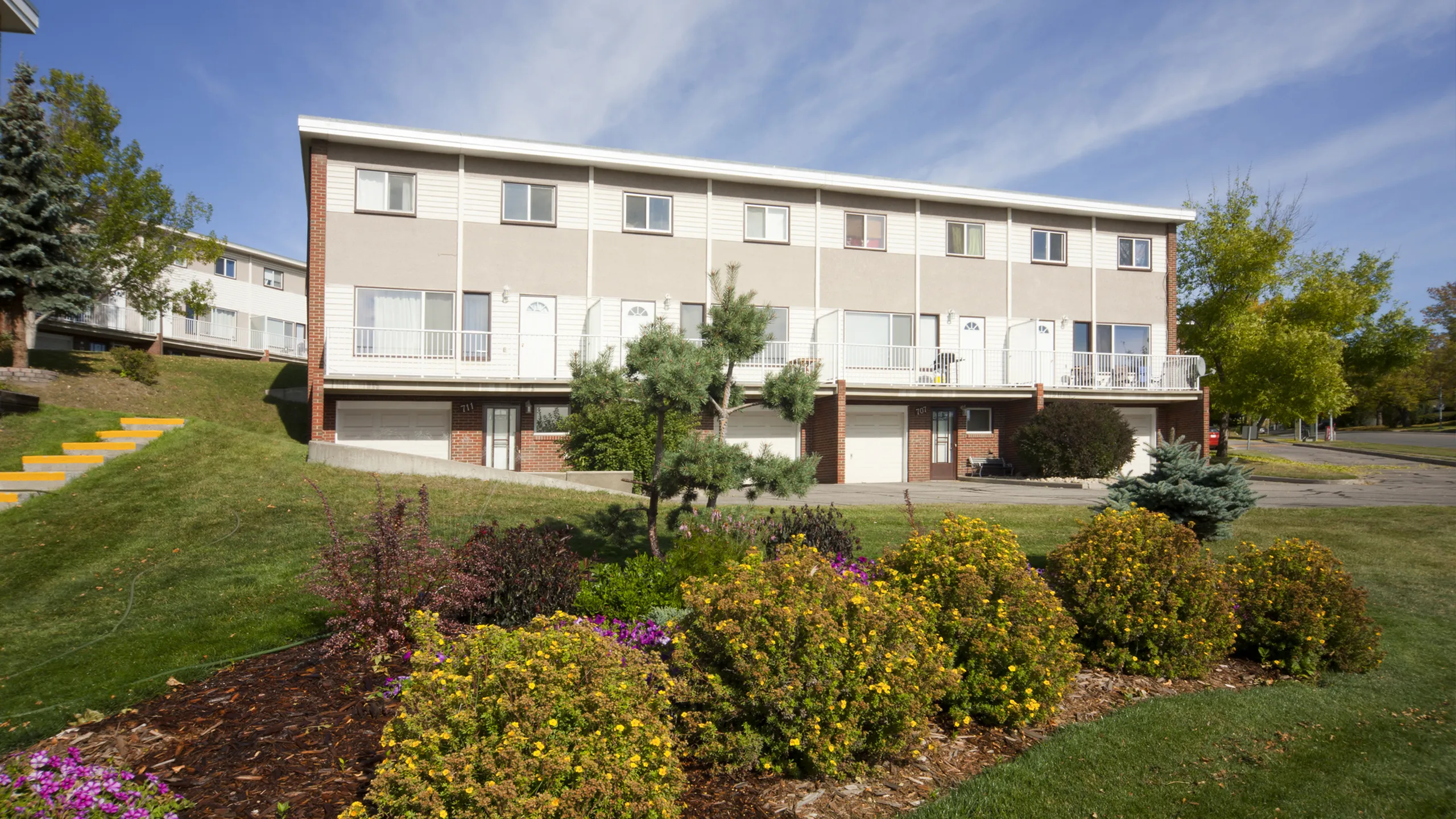 Charming townhouses with modern design surrounded by lush greenery and vibrant gardens.