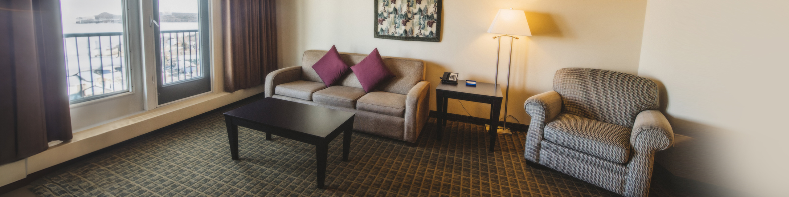 Inviting living room with cozy seating, stylish throw pillows, warm lighting, and large windows providing a scenic view.