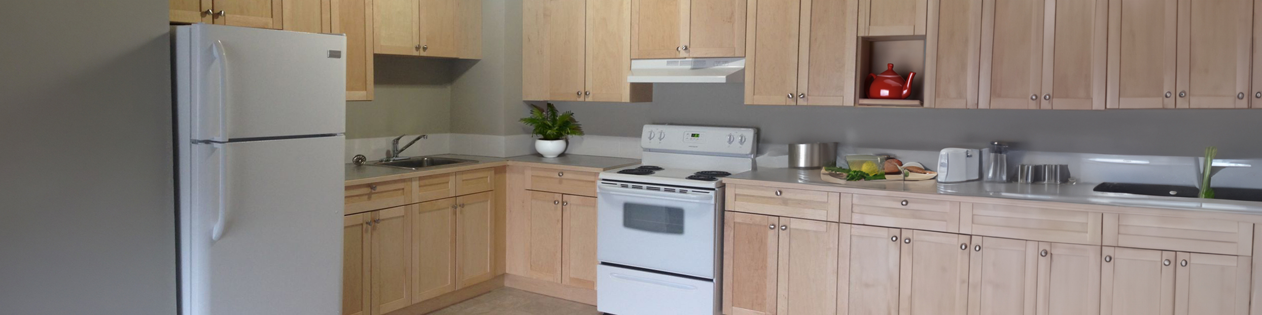 Inviting kitchen with light wooden cabinets, modern appliances, and sleek countertops, perfect for culinary enthusiasts.