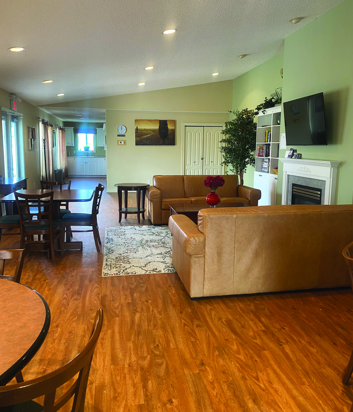 Inviting living area with elegant wooden floors, cozy leather couches, and a modern fireplace, perfect for relaxation and entertainment.